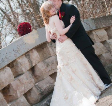 Bride and groom embracing on a stone bridge