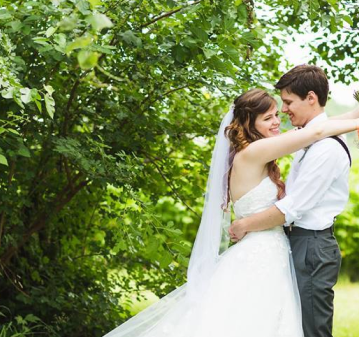 Bride and groom embracing in a wooded outdoor setting