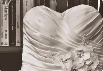 Close-up detail of a wedding gown's beaded lace appliqué and bodice ruching