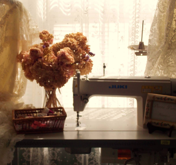 Vintage sewing machine on a workshop table with dried flowers