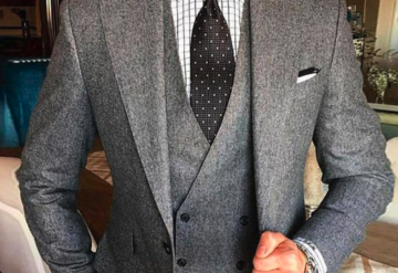 Close-up of a gray herringbone suit with a patterned tie